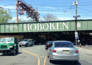 green train bridge with welcome to hoboken painted on it.